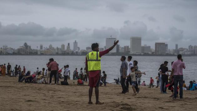A life guard warns people as high-tide approaches at Girgaon chowpatty. Following the warnings issued by IMD, the Brihanmumbai Municipal Corporation (BMC) cancelled leaves of all senior officials, including deputy municipal commissioners, assistant commissioners and heads of departments as a precautionary measure. (Pratik Chorge / HT Photo) A life guard warns people as high-tide approaches at Girgaon chowpatty. Following the warnings issued by IMD, the Brihanmumbai Municipal Corporation (BMC) cancelled leaves of all senior officials, including deputy municipal commissioners, assistant commissioners and heads of departments as a precautionary measure. (Pratik Chorge / HT Photo)