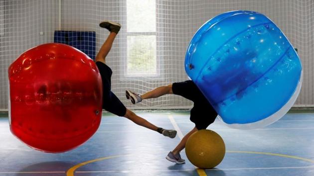 Schoolchildren play bumper ball, the game involving strapping football players into giant inflatable balls, at a sports facility in Moscow, Russia. (Tatyana Makeyeva / REUTERS)
