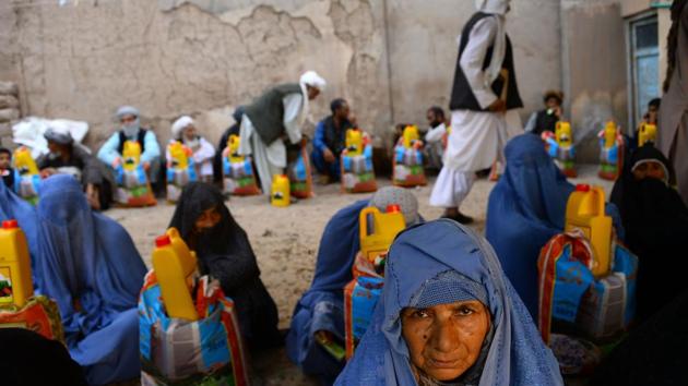 Burqa-clad women receive aid by a charity during Ramdan in Herat province, Afghanistan. (Hoshang Hashimi / AFP)