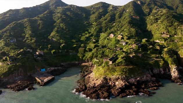 A view of the abandoned village houses covered with overgrown vegetation. Visitors must take a boat to Shengshan then a taxi up a hill to a cemetery overlooking the village, and then descend down perilous footpaths into the mist and ivy. (Johannes Eisele / AFP) A view of the abandoned village houses covered with overgrown vegetation. Visitors must take a boat to Shengshan then a taxi up a hill to a cemetery overlooking the village, and then descend down perilous footpaths into the mist and ivy. (Johannes Eisele / AFP)