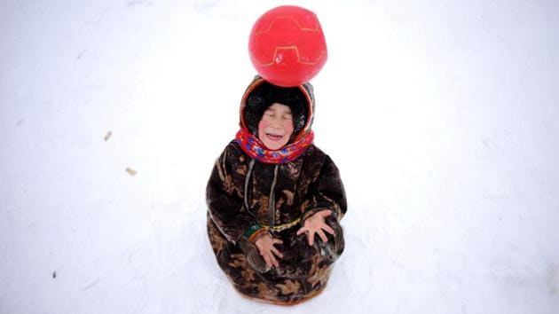 Children of reindeer herders play with a ball on the snow in the remote Yamalo-Nenets region of northern Russia. (Sergei Gapon / AFP)