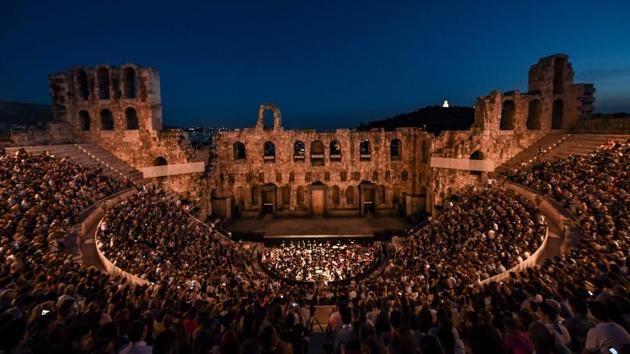 People wait in the Greek ancient theater of Odeon of Herodes Atticus to watch the Nabucco opera in Athens, Greece. (Aris Messinis / AFP)