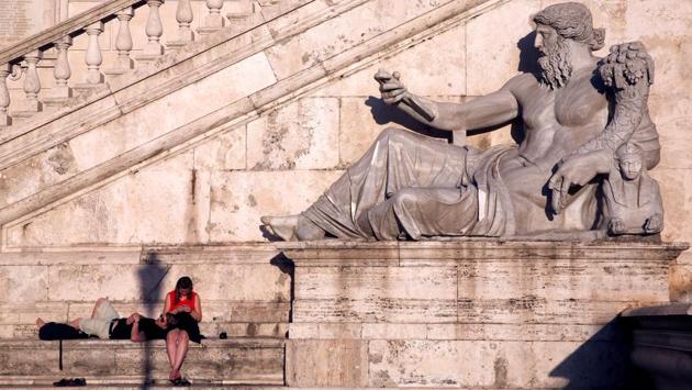 Tourists rest near a statue at the top of Capitoline Hill in Rome, Italy. (Stefano Rellandini / REUTERS)