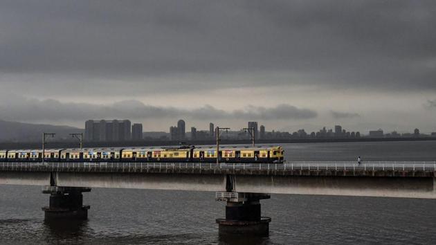 A suburban train runs across a bridge on Vashi creek as dark monsoon clouds hover. Although railway tracks near Sion and Thane were submerged under water, train services largely remained functional with delays reported in the suburban sections of the city. (PTI) A suburban train runs across a bridge on Vashi creek as dark monsoon clouds hover. Although railway tracks near Sion and Thane were submerged under water, train services largely remained functional with delays reported in the suburban sections of the city. (PTI)