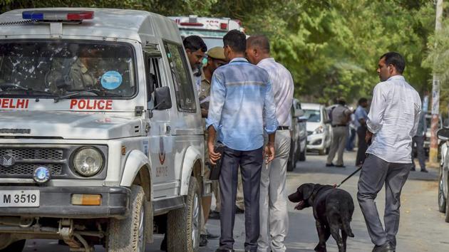 Police personnel and forensic experts inspect the site of an encounter between the Special Cell and a gang of criminals in the Chattarpur area of south Delhi on Saturday.(PTI Photo)