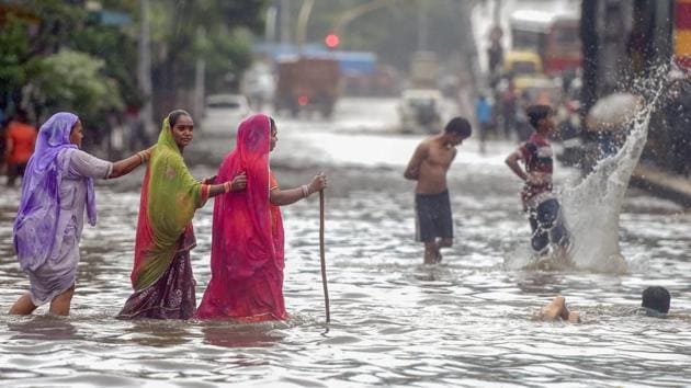 Women cross a waterlogged street at Mumbai’s King Circle. The Indian Meteorological Department (IMD) has forecasted heavy rains with thundershowers in the city and suburbs over the next 48 hours, with isolated extreme heavy rainfall in some areas till Monday. (Shashank Parade / PTI)