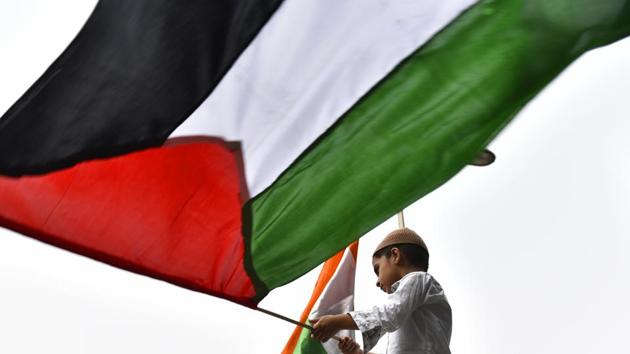 A boy hurls Palestine flag as members of Majlis-e-Ulama-e-Hind protest against the illegal occupation of Israel on Holy Al-Aqsa Mosque, the relocation of US Embassy from Tel Aviv to Jerusalem and the atrocities being conducted by Israel against innocent people, at Jantar Mantar in New Delhi, on June 8, 2018. (Sanchit Khanna/HT PHOTO) A boy hurls Palestine flag as members of Majlis-e-Ulama-e-Hind protest against the illegal occupation of Israel on Holy Al-Aqsa Mosque, the relocation of US Embassy from Tel Aviv to Jerusalem and the atrocities being conducted by Israel against innocent people, at Jantar Mantar in New Delhi, on June 8, 2018. (Sanchit Khanna/HT PHOTO)