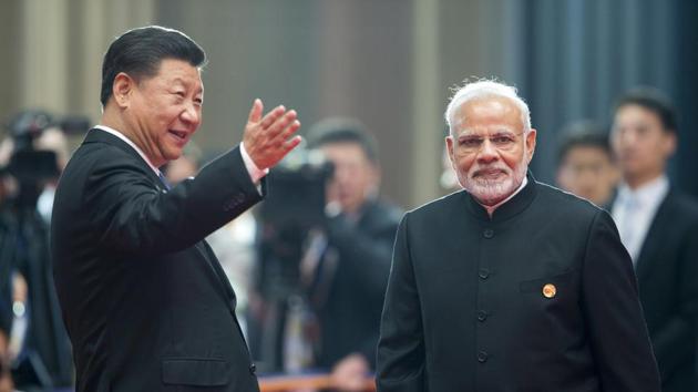 Chinese President Xi Jinping, left, welcomes Prime Minister Narendra Modi for a meeting at the Shanghai Cooperation Organisation (SCO) Summit in Qingdao in eastern China's Shandong Province on Sunday.(AP Photo)