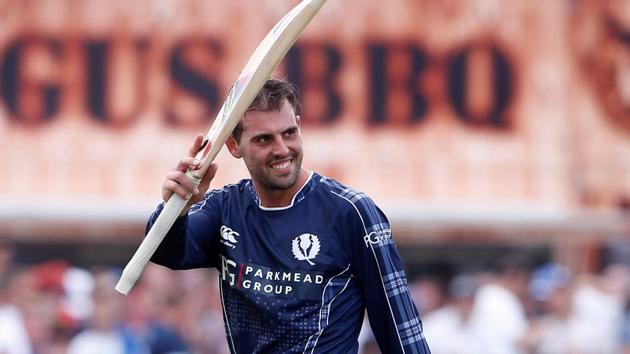 Scotland's Calum MacLeod waves as he walks off after completing their innings.(Reuters)