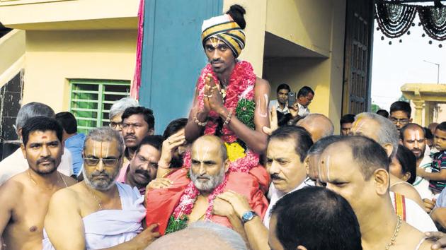 Hyderabad priest CS Rangarajan carrying Aditya Parasari into the Sri Ranganatha temple at Jiaguda on April 16.(HT Photo)
