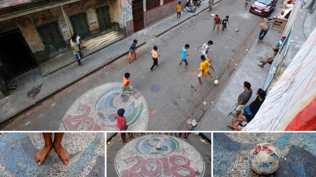 On a dusty Kolkata street, painted with a 2018 World Cup logo children brave traffic for a barefoot game. One of them is a fan of Argentinean forward Lionel Messi, another worships Portuguese striker Cristiano Ronaldo. Both Messi and Ronaldo are contemporary legends but still haven’t quite proved themselves on the grandest stage yet. Will one come out better this time? Time will tell. (Rupak De Chowdhuri / REUTERS)