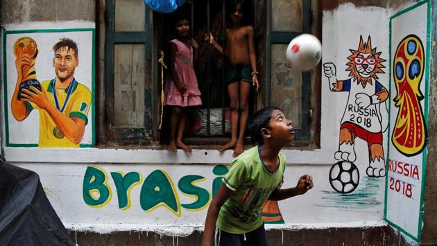 A boy plays in front an image of Brazil's Neymar painted on a wall in an alley. (REUTERS)