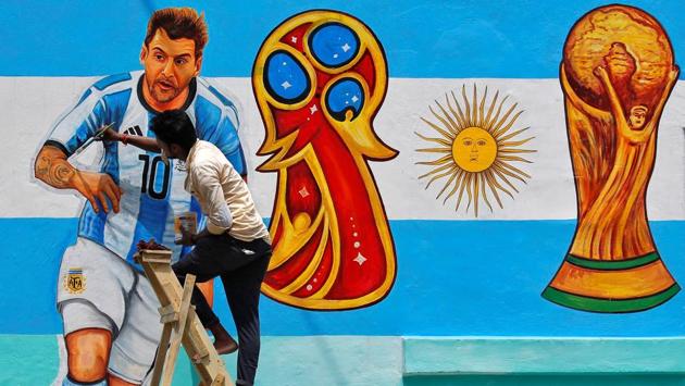 A painter applies finishing touches to an image of Lionel Messi. (REUTERS)