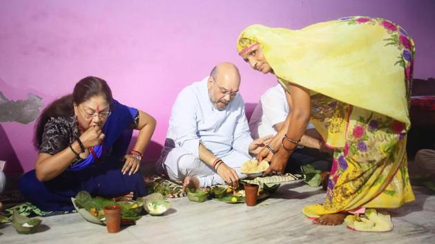BJP national president Amit Shah, along with CM Vasundhara Raje, have lunch at a Dalit's home in Jaipur on Sunday.(Himanshu Vyas/HT Photo) BJP national president Amit Shah, along with CM Vasundhara Raje, have lunch at a Dalit's home in Jaipur on Sunday.(Himanshu Vyas/HT Photo)