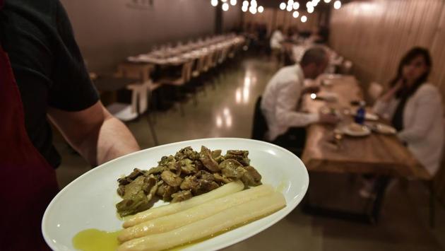 A cook holds a plate with white asparagus ready to be eaten, at a restaurant in Pamplona. Locals eat them by holding them with two fingers, upside down and above the head, and slowly bringing them down and into the mouth. The best asparaguses are said to melt at the touch of the tongue. (Alvaro Barrientos / AP) A cook holds a plate with white asparagus ready to be eaten, at a restaurant in Pamplona. Locals eat them by holding them with two fingers, upside down and above the head, and slowly bringing them down and into the mouth. The best asparaguses are said to melt at the touch of the tongue. (Alvaro Barrientos / AP)