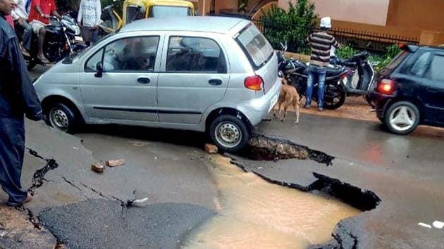 A damaged road following heavy rains in Karnataka’s Dharwad on Sunday.(PTI Photo)