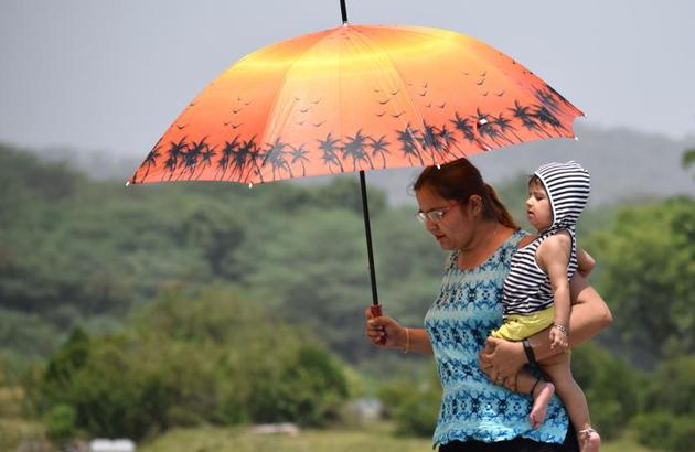 A woman using an umbrella to brave the heat at Sukhna Lake in Chandigarh on Monday. (Sikander Singh/HT) A woman using an umbrella to brave the heat at Sukhna Lake in Chandigarh on Monday. (Sikander Singh/HT)