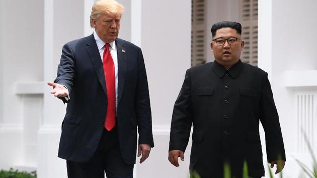 North Korea's leader Kim Jong Un walks with US President Donald Trump (L) during a break in talks at their historic US-North Korea summit, at the Capella Hotel on Sentosa island in Singapore on June 12, 2018.(AFP)