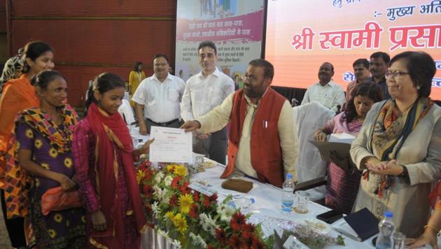 Swami Prasad Maurya giving certificates to children linked with welfare scheme.(Deepak Gupta/HT Photo)