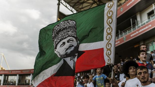 A fan with a flag bearing the image of Akhmad Kadyrov, a president of Chechnya who was assassinated in 2004, in Grozny, Russia. (NYT) A fan with a flag bearing the image of Akhmad Kadyrov, a president of Chechnya who was assassinated in 2004, in Grozny, Russia. (NYT)