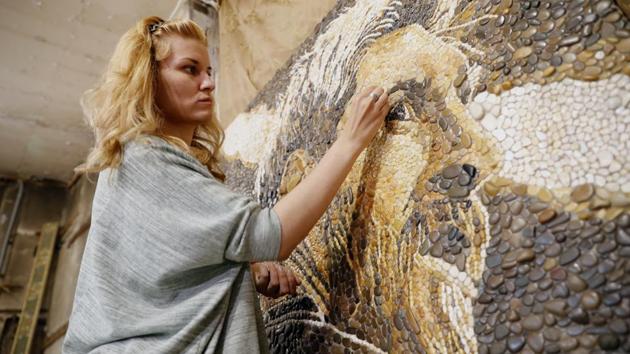 Anna Solnechnaya shows her creation of one of the pebble mosaics depicting Argentina's Lionel Messi in Kazan. (AP) Anna Solnechnaya shows her creation of one of the pebble mosaics depicting Argentina's Lionel Messi in Kazan. (AP)