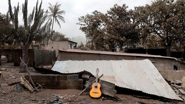 A guitar is seen on the roof of a damaged house. By the time most families in the worst-hit hamlets of El Rodeo and San Miguel de Los Lotes knew what was happening, they only had time to run, if that. (Carlos Jasso / REUTERS)