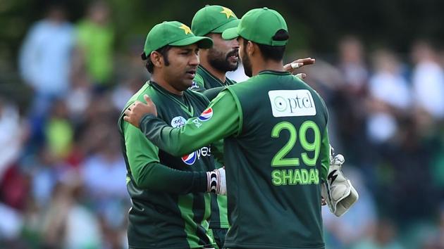 Pakistan skipper Sarfraz Ahmed (L) celebrates with Shadab Khan following the first Twenty20 International cricket match between Scotland and Pakistan at the Grange Cricket Club in Edinburgh, Scotland, on June 12, 2018. Pakistan won the match by 48 runs.(AFP)