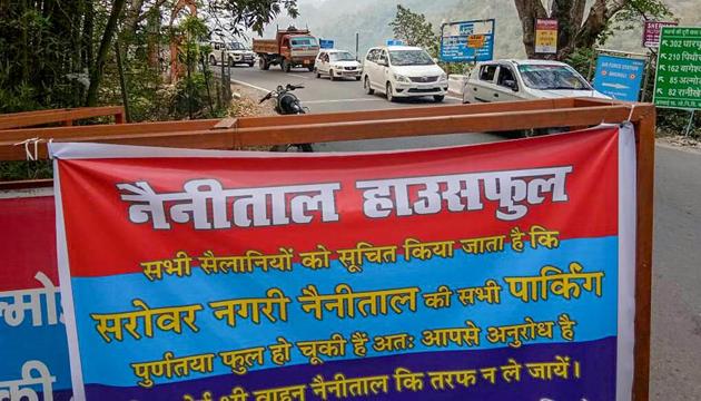 A banner tied to a barricade reads' the popular hill station of Nainital has shut its parking for tourists arriving in their vehicles as it is housefull', in Nainital. (PTI) A banner tied to a barricade reads' the popular hill station of Nainital has shut its parking for tourists arriving in their vehicles as it is housefull', in Nainital. (PTI)