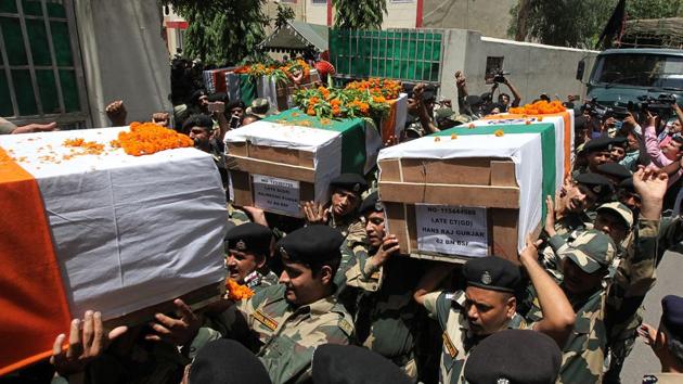 Border Security Force (BSF) officers carry the coffin of slain soldiers during a wreath-laying ceremony at the BSF headquarters in Jammu. Cross border firing left four BSF personnel dead on June 13 along the border dividing disputed Kashmir with the Pakistani province of Punjab. (AFP)