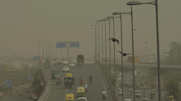 Vehicles ply slowly on a road as dust envelopes the sky over New Delhi, on Wednesday.(Manvender Vashisht/PTI Photo)