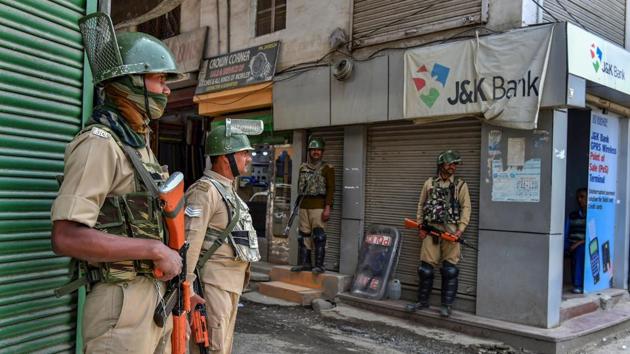 CRPF personnel stand guard near a shop on the first day of Ramadan, in Srinagar.(PTI File Photo)