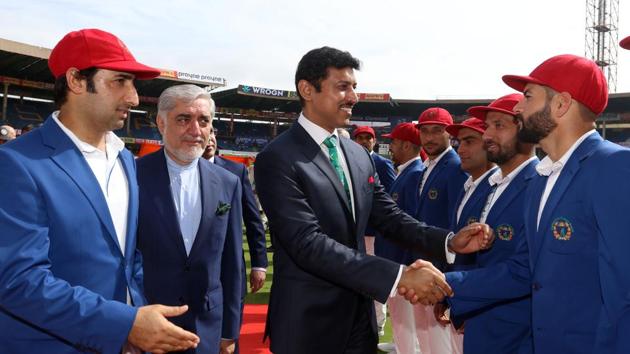 Sports Minister Rajyavardhan Singh Rathore greets Afghanistan players in action during day one of the Test match between India and Afghanistan at the M. Chinnaswamy Stadium in Bangalore.(BCCI)