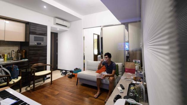 Finance worker Adrian Law, 25, eats a meal in his studio apartment, for which he paid more than 765,000 USD two years ago in the gentrified Sai Ying Pun neighbourhood. The slim glass building squeezes four apartments onto each floor and includes “nano-flats”, a new term for homes of under 215 square feet (20 square metres). (Isaac Lawrence / AFP)