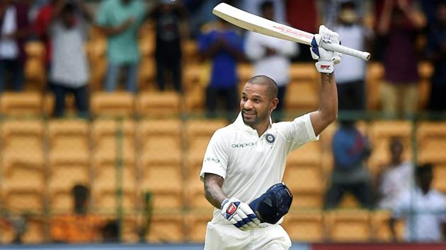 Shikhar Dhawan celebrates his century during the one-off cricket test match against Afghanistan at Chinnaswamy Stadium in Bengaluru. The Indian team were comfortably cruising against the Asghar Stanikzai led Afghan team with 254 runs already on the board with loss of just one wicket before rain interrupted play minutes after the post-tea session resumed on Day 1 of the match. (Shailendra Bhojak / PTI) Shikhar Dhawan celebrates his century during the one-off cricket test match against Afghanistan at Chinnaswamy Stadium in Bengaluru. The Indian team were comfortably cruising against the Asghar Stanikzai led Afghan team with 254 runs already on the board with loss of just one wicket before rain interrupted play minutes after the post-tea session resumed on Day 1 of the match. (Shailendra Bhojak / PTI)