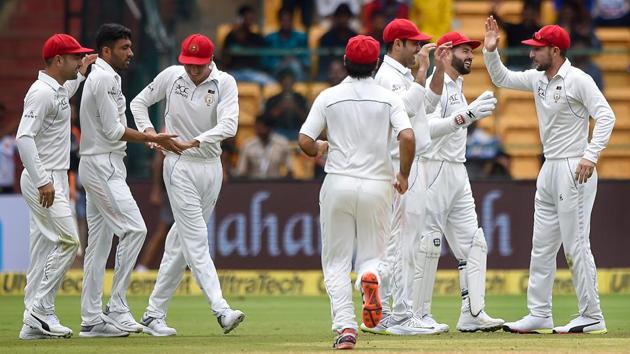 Afghanistan bowler Yamin Ahmadzai celebrates with teammates the wicket of India's Shikhar Dhawan during their one-off Test at Chinnaswamy Stadium in Bengaluru on Thursday.(PTI)