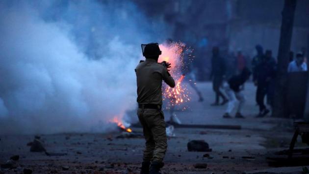 A police officer fires a tear gas shell towards protesters in Srinagar.(Reuters File Photo)