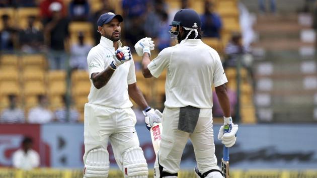 India's Murali Vijay, right, greets teammate Shikhar Dhawan, left, on hitting a boundary during the one-off cricket test match against Afghanistan in Bangalore.(AP)