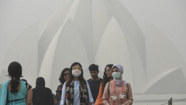 New Delhi, India - Nov. 7, 2017: Foreign tourists wearing masks as they visit Lotus Temple on a smoggy morning, in New Delhi, India, on Tuesday, November 7, 2017. The national capital’s air quality dipped to ‘severe’ with Tuesday morning beginning on a hazy note. Reports from Haryana and Punjab also indicated similar smog-like conditions. (Photo by Burhaan Kinu/ Hindustan Times)(Burhaan Kinu/HT PHOTO)