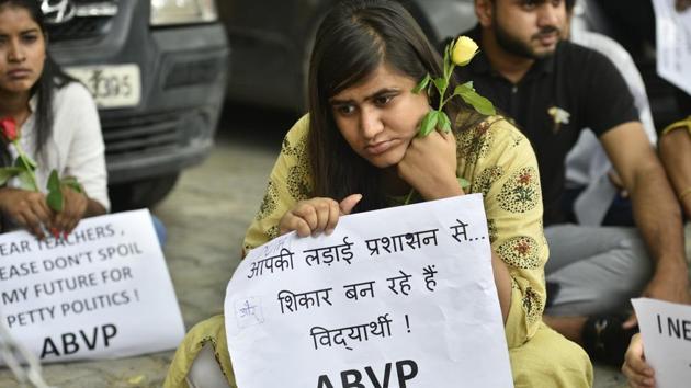 A member of Akhil Bharatiya Vidyarthi Parishad (ABVP) holds a placard while protesting against the Delhi University Teacher's Association (DUTA), asking them to roll-back the decision of not evaluating the copies of students, outside the Press Club of India in New Delhi on June 11, 2018. (Anushree Fadnavis / HT Photo)