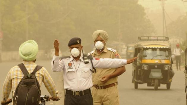 Traffic policemen wearing masks as they manage traffic in Patiala on Friday. (Bharat Bhushan /HT)