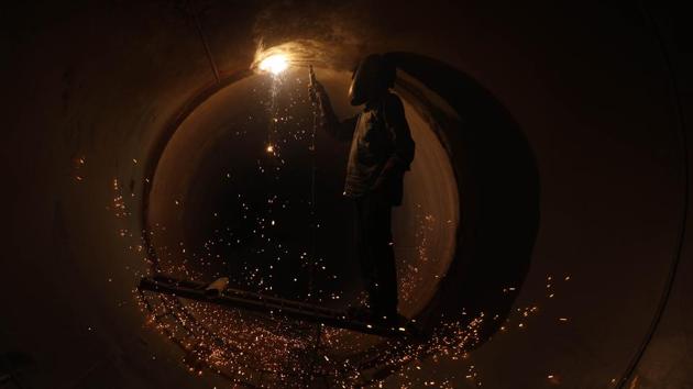 A welder fuses the seams of a water pipeline at Sarasbaug in Pune, Maharashtra on June 11, 2018. (Rahul Raut / HT Photo)