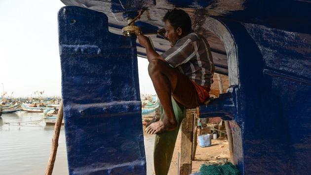 A fisherman performs maintenance work at a harbour in Chennai, Tamil Nadu on June 13, 2018. (Arun Sankar / AFP)