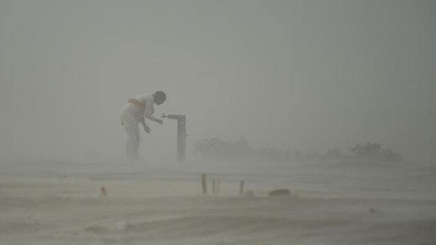 A devotee drinks from a tap during a dust storm at the Sangam, the confluence of the rivers Ganges, Yamuna and Saraswati in Allahabad, Uttar Pradesh, on June 13, 2018. (Sanjay Kanojia / AFP)