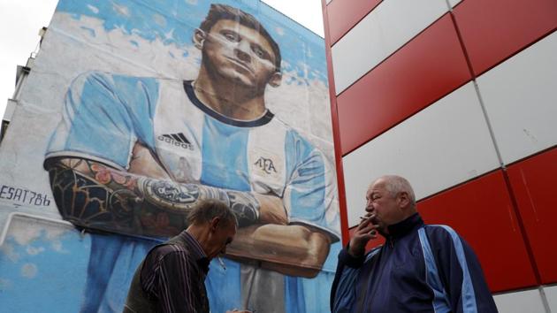 Flags bearing Lionel Messi’s face hang over barriers, while a giant mural of the Barcelona star towers above the people of Bronnitsy as they come to terms with the intense spotlight now fixated on their hometown.(AP)