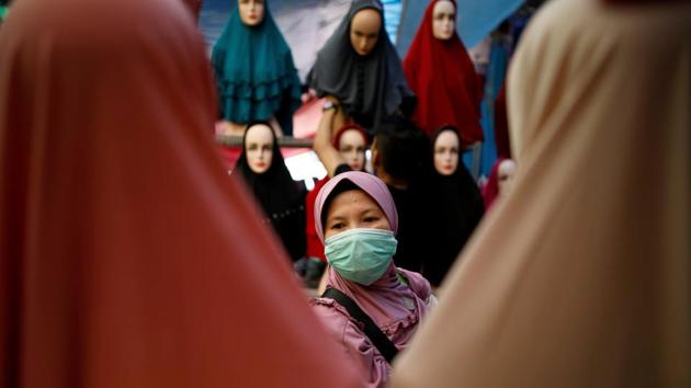 A woman shops for clothes at Tanah Abang traditional market ahead of the Eid al-Fitr holiday in Jakarta, Indonesia. (Darren Whiteside / REUTERS) A woman shops for clothes at Tanah Abang traditional market ahead of the Eid al-Fitr holiday in Jakarta, Indonesia. (Darren Whiteside / REUTERS)