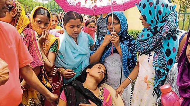 Domestic helps protest against the alleged assault on Maya Das (centre) outside Westend Heights on Friday. (Parveen Kumar/HT Photo) Domestic helps protest against the alleged assault on Maya Das (centre) outside Westend Heights on Friday. (Parveen Kumar/HT Photo)