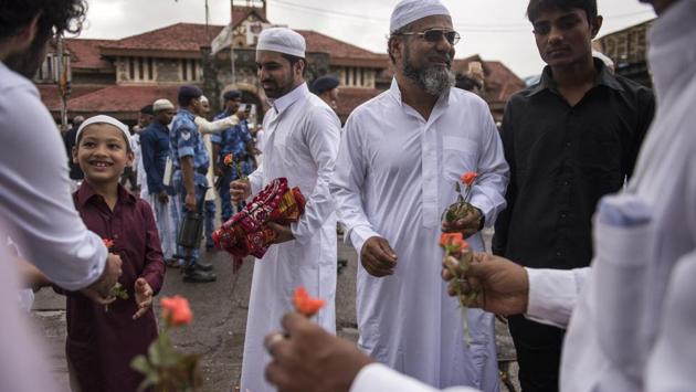 People exchange roses after the Eid-ul-Fitr prayers outside Bandra (West) station in Mumbai. (Satish Bate / HT Photo)