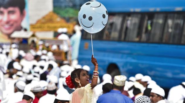 A girl plays with a balloon on the occasion of Eid-ul-Fitr at Mysore Road Eidgah in Bengaluru. (Arijit Sen / HT Photo)