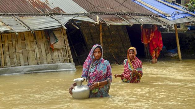 Villagers carry clean water as they wade across flood-affected areas at Nilambazar village, in Karimganj on Sunday.(PTI) Villagers carry clean water as they wade across flood-affected areas at Nilambazar village, in Karimganj on Sunday.(PTI)