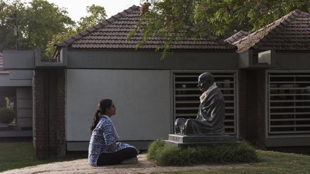 A tourist meditates in front of Gandhi’s statue at the Ashram Museum. While the heat outside is difficult to bear even for locals, the blistering June weather fails to keep tourists –both national and international –from visiting the Ashram. Atul Pandya, director, Sabarmati Ashram Preservation and Memorial Trust said that there are more than 4,000 visitors, daily. (Aalok Soni / HT Photo) 
